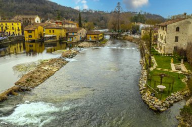 Valeggio, İtalya - 03-02-2022: Suya yansıyan binaların bulunduğu banliyö konsolosu Mincio 'nun yüksek açılı manzarası