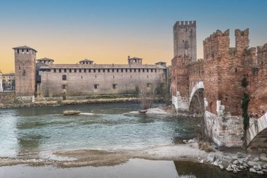 Verona, İtalya - 03-04-2022: Güzel Castelvecchio ve gün batımında Verona 'daki Adige nehri üzerindeki köprü