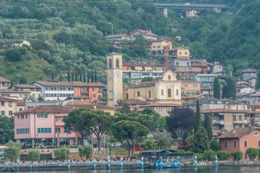 Sulzano, İtalya - 05-06-2022: Sulzano göl kenarındaki panorama ve Iseo Gölü 'ne yansıyan renkli evler