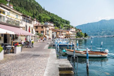 Monte Isola, İtalya - 05-06-2022: Peshiera Maraglio gölünün manzarası Monte Isola 'da suda yansıyan güzel renkli evlerle