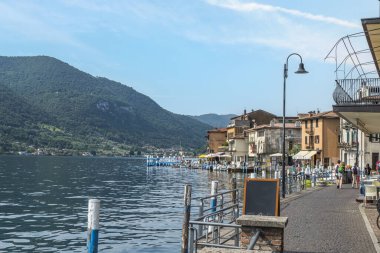 Monte Isola, İtalya - 05-06-2022: Peshiera Maraglio gölünün manzarası Monte Isola 'da suda yansıyan güzel renkli evlerle