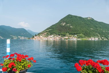 Monte Isola, İtalya - 05-06-2022: Peshiera Maraglio gölünün manzarası Monte Isola 'da suda yansıyan güzel renkli evlerle