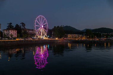 Luino, İtalya: 05-18-2021: Dönme dolap Luino 'daki Maggiore Gölü' nün ışıklarıyla aydınlandı