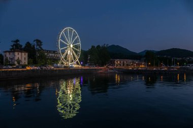 Luino, İtalya: 05-18-2021: Dönme dolap Luino 'daki Maggiore Gölü' nün ışıklarıyla aydınlandı
