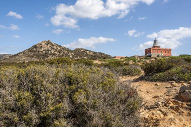 Sardunya 'nın güneyindeki Capo Spargivento' nun güzel kırmızı deniz feneri.