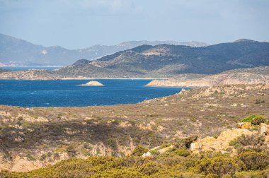 Landscape of the south-west coast of Sardinia with cliffs, blue sea, fjords and white clouds clipart