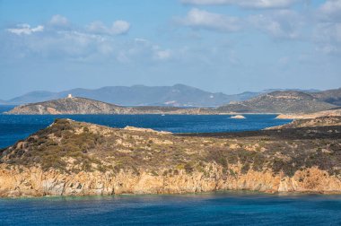 Sardunya 'nın güneybatı kıyılarında kayalıkları, mavi denizi, fiyortları ve beyaz bulutları olan bir manzara.