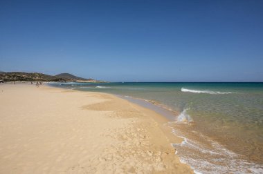 Sardinya 'nın güneyinde, şeffaf ve turkuaz suyu ve körfezin önünde küçük bir adası olan Su Giudeu' nun güzel plajı.
