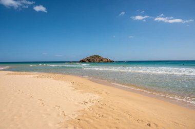 Sardinya 'nın güneyinde, şeffaf ve turkuaz suyu ve körfezin önünde küçük bir adası olan Su Giudeu' nun güzel plajı.