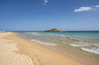 Sardinya 'nın güneyinde, şeffaf ve turkuaz suyu ve körfezin önünde küçük bir adası olan Su Giudeu' nun güzel plajı.