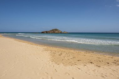 Sardinya 'nın güneyinde, şeffaf ve turkuaz suyu ve körfezin önünde küçük bir adası olan Su Giudeu' nun güzel plajı.