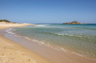 Sardinya 'nın güneyinde, şeffaf ve turkuaz suyu ve körfezin önünde küçük bir adası olan Su Giudeu' nun güzel plajı.
