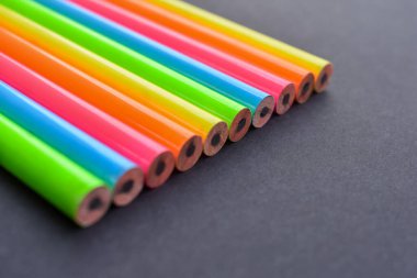 Siyah arkaplandaki rengarenk kalemler. Okul konseptine geri dönelim. Keskin olmayan yeni kalemler grubu. Çok renkli kalem arkaplanı.