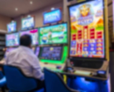 Kumarhanenin içindeki kumar makinesinde oturan adam