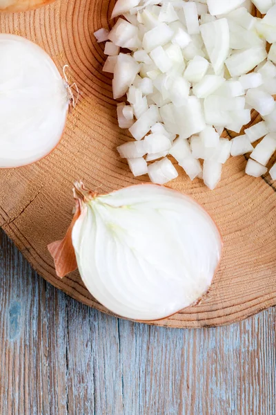 stock image Onions cut in half and chopped on an old wooden board. Top view.