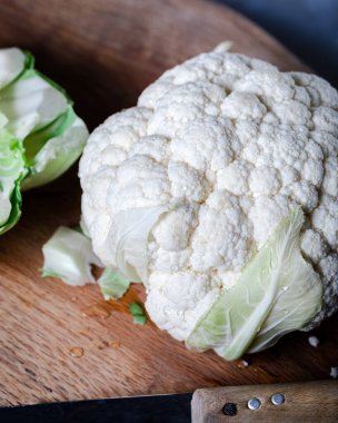 Kesme tahtasında taze karnabahar. Tahtadaki beyaz karnabahar bıçakla.