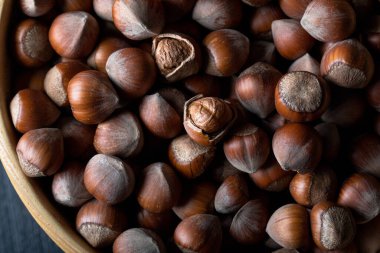 Fındıklı ahşap bir kasenin üstünde. Arka planda bir kasede fındık. Yakın plan. Üst görünüm.