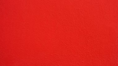 Textured wall in vibrant saturated red color.