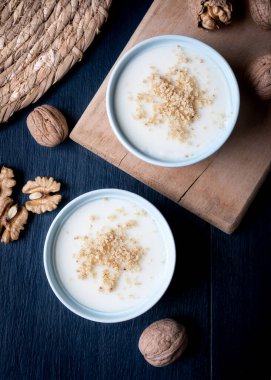 Homemade custard with walnut, Turkish dessert muhallebi on a wooden background. Homemade custard with walnut. 