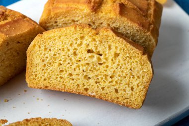 Beautiful homemade yellow, sliced cornbread loaf. Freshly baked cornbread on wooden background.