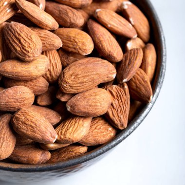 Beyaz arka planda bir kasede taze badem. Beyaz arka planda bir kase badem. Yakın plan.. 