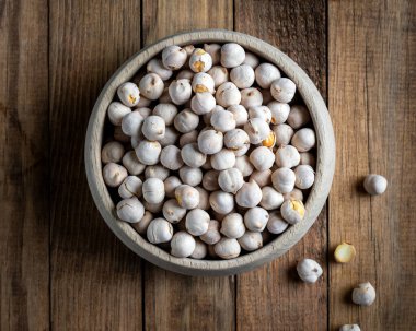 Ahşap kasede kavrulmuş beyaz nohut, ahşap zemin üzerinde geleneksel Türk fındığı. Türk leblebi, ünlü fındık, bir yığın sarı kavrulmuş nohut.