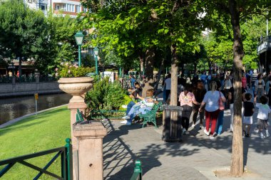 Eskisehir, Türkiye - 06-23-2023: Güneşli bahar gününün tadını çıkaran insanlar Porsuk Nehri, Eskisehir. 