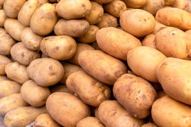Pazarda sebze tezgahında satılan taze patates yığını..