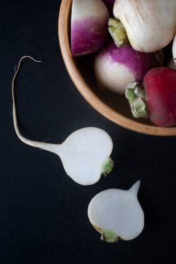 Daikon turpları siyah arka planda ahşap bir kasede