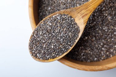 Beyaz arka planda tahta kaşıkta Chia tohumları. Kapat..