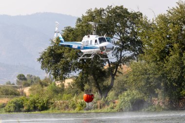 REDDDDING CALIFORNIA 10 AĞUSTOS 2024 Bir Çan UH1 helikopteri Mary Gölü 'nden aşağı taraftaki yangınla savaşmak için suya daldı / Keswick.