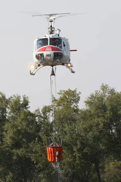 REDDDDING CALIFORNIA 10 AĞUSTOS 2024 Bir CALFIRE Çanı UH1 helikopteri Mary Gölü 'nden suyla havalanarak Lower Fire ile savaşmak için Lower Springs ve Keswick.