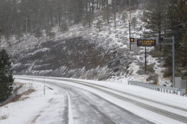 Kaliforniya, Lassen County 'de 36. karayolunu kar ve buzla kaplayan bir kış fırtınası, yol kenarı tabelası, sürücüleri önlerindeki buz kıvrımları konusunda uyardı..