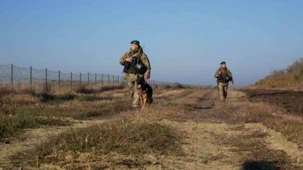ウクライナのハリコフ 2021年10月1日国境警備隊が国境をパトロールしている 国境沿いに犬の散歩を持つ3人の武装国境警備員 — ストック動画
