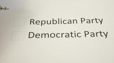 Bir kalem, ABD senatosu ara seçimlerinde Cumhuriyetçi Parti 'nin oy kullanma merkezinin önündeki bir oy pusulasına işaret koyuyor. Oy hakkı, seçim, oy kullanma kavramı. Cumhuriyetçiler ve