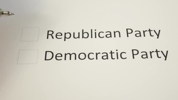 ペンは 米国上院中間選挙の投票所で共和党の列の前に紙の投票にマークを置きます 投票の概念 共和党と — ストック動画
