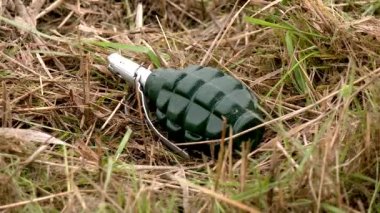 Bir savaş bombası kuru çimlerin üzerinde yatıyor. Patlayıcılarla gerilmek tehlikelidir. Mayınlı alanlar ve nesneler. Rus ordusu işgal edilmiş toprakları mayınlıyor. Özgürleştirilmiş bölgelerin kurutulması