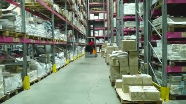 Kharkiv, Ukrayna - 3 Şubat 2022: depoda bir forklift hareket ediyor. Sağ ve sol raflarda kutular var. Depo lojistiği