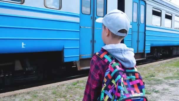 Восьмирічний Хлопчик Рюкзаком Плечах Стоїть Біля Залізничної Станції Дивиться Поїзд — стокове відео