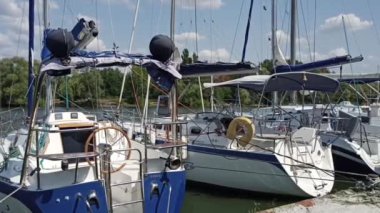 Rıhtımdaki beyaz kayıklar. Arkaplanda yeşil ağaçlar