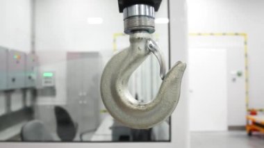 A large crane hook in production. White steel hook moves to the side