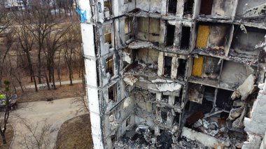 A multi-storey apartment building in a Ukrainian city destroyed by a Russian missile strike. Destroyed entrance of a panel house. Shooting from a drone. Lifeguards walk on the roof of the house