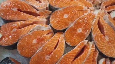 Pieces of red salmon fish on ice on a supermarket counter. Proper nutrition