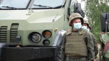 Kharkiv, Ukraine - May 29, 2021: Soldiers of the National Guard in bulletproof vests and helmets stand near an armored personnel carrier