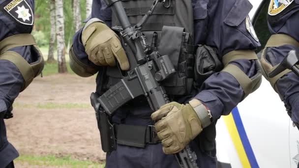 防弾チョッキを着た警官が手袋をしてる彼の手に機銃を持ってる — ストック動画
