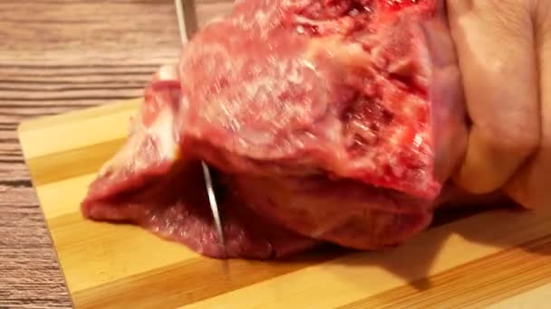 女性の手は キッチンのまな板にナイフで牛肉の一部をカットしました 肉料理 — ストック動画