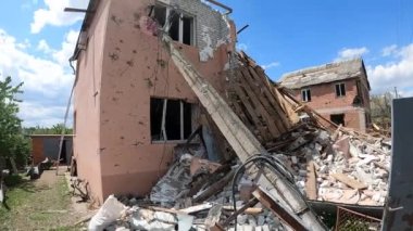 Topçu bombardımanı sonucu yıkılan özel bir ev. Çatı yok, pencere yok, yıkılmış duvarlar, tuğla dağının yanında.