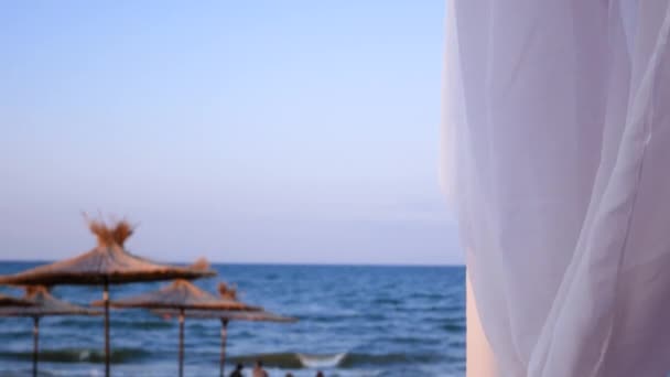 Beach Blue Sea Straw Umbrellas Visible Distance White Fabric Gazebo — Stockvideo