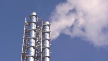 From the pipes of the mini-boiler room comes white smoke against the background of the blue sky. Production of heat and hot water for residents of the city. Energy security. Infrastructure facility