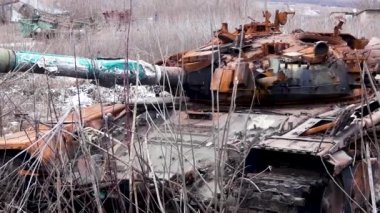 Köy yakınlarındaki bir tarlada kurumuş otların arasında paslanmış bir tank duruyor. Rus-Ukrayna Savaşı 2022-2023. Rus ordusunun saldırısı, Ukrayna topraklarının işgali.